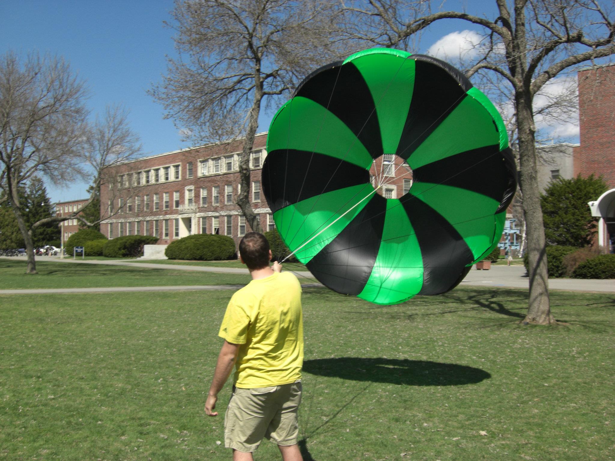 Alex holding an inflated parachute on the mall of the University of Maine